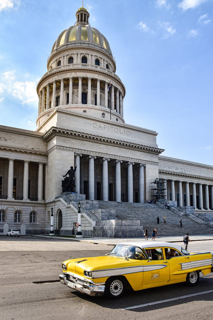 A Vintage Yellow Car in front of the National Capitol of Cuba