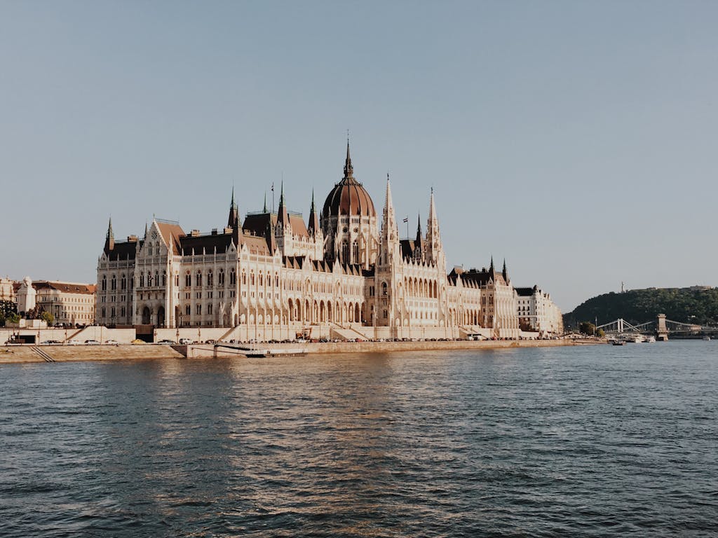 Stunning view of the Hungarian Parliament Building along the Danube River in Budapest during the day.